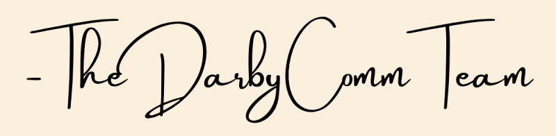 Handwritten cursive text reads: - The DarbyComm Team on a light beige background. Darby Communications PR + Digital Marketing